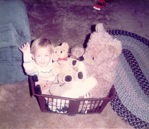SW Hammond as a small child, sitting in a laundry basket with stuffed animals.